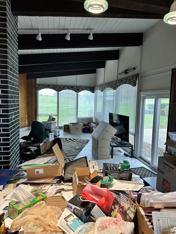 A living room packed with boxes and files